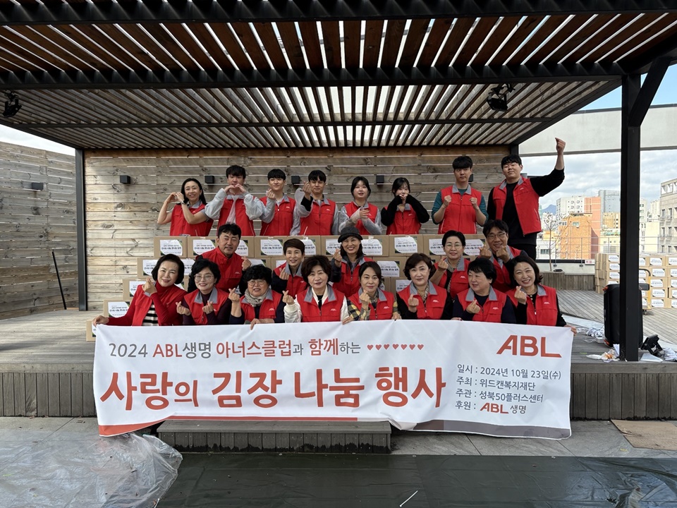 2024 ABL생명 아너스클럽과 함께하는 사랑의 김장 나눔 행사, 일시 : 2024년 10월 23일(수), 주최 : 위드캔복지재단, 주관 : 성북50플러스센터, 후원 : ABL생명, ABL, 문구가 쓰여진 현수막을 들고 단체사진을 찍고있는 모습